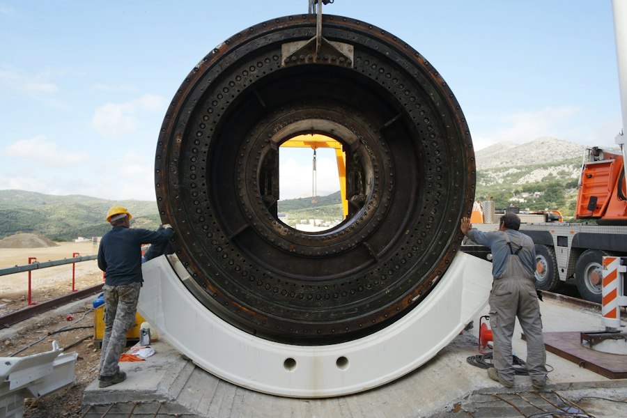 Crew beside a large-diameter pipe section on site