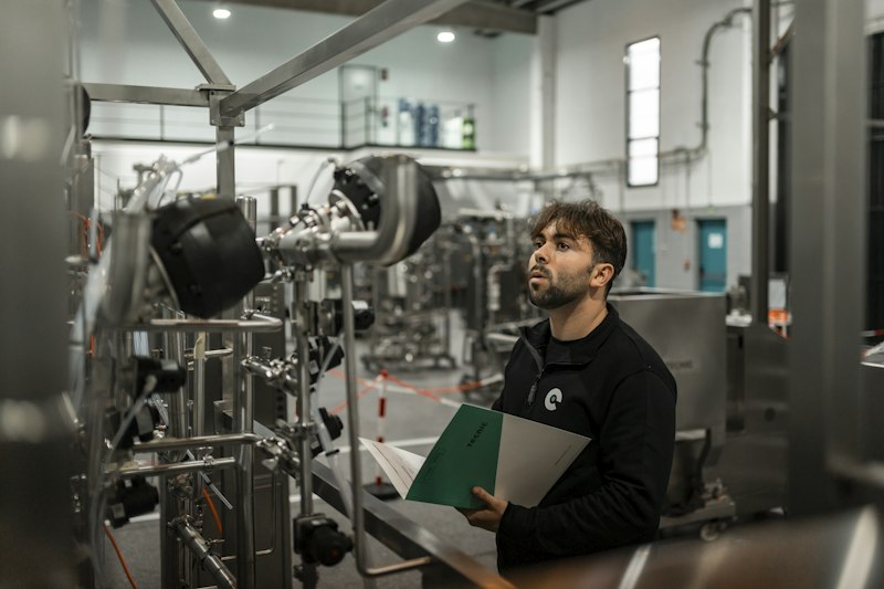 Inspector examining machinery on a plant floor