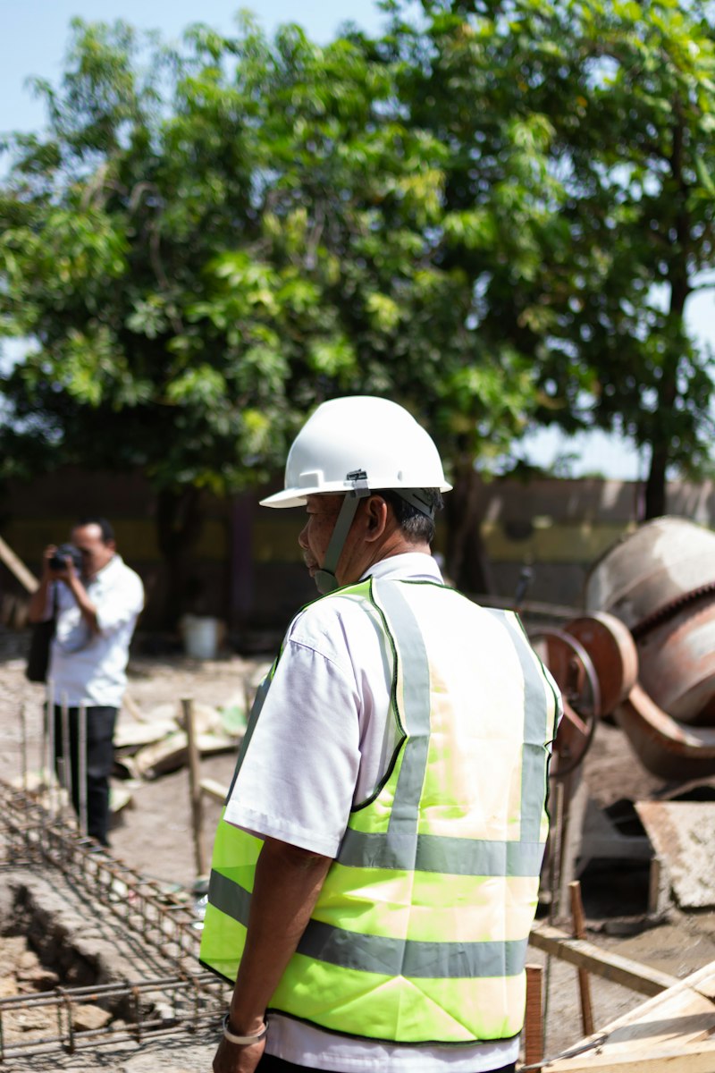 Site supervisor in a hard hat and vest on a job site